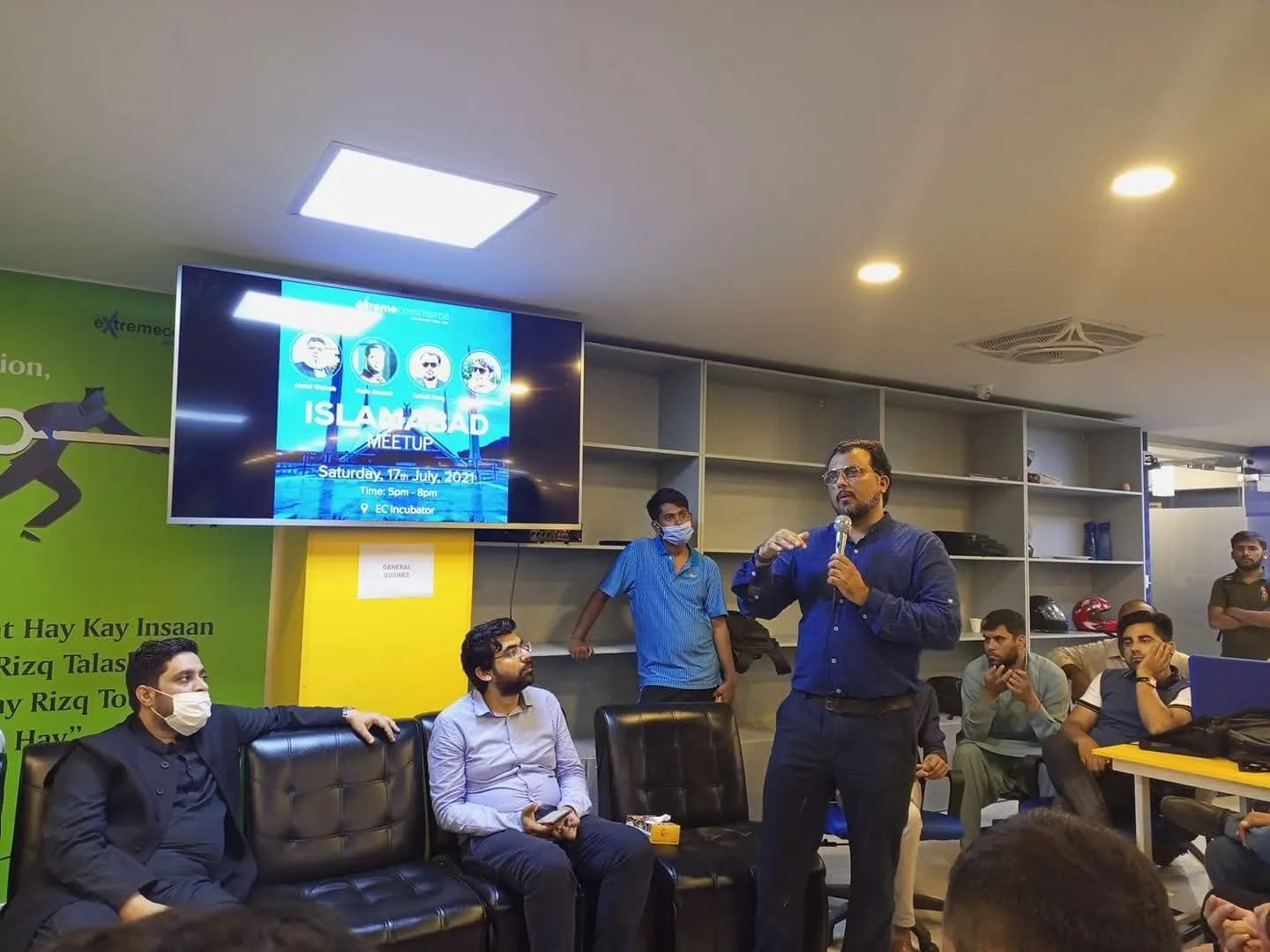 Taimoor Bamazai seated on the left in a face mask, listening to another speaker at the Islamabad MeetUp, July 2021