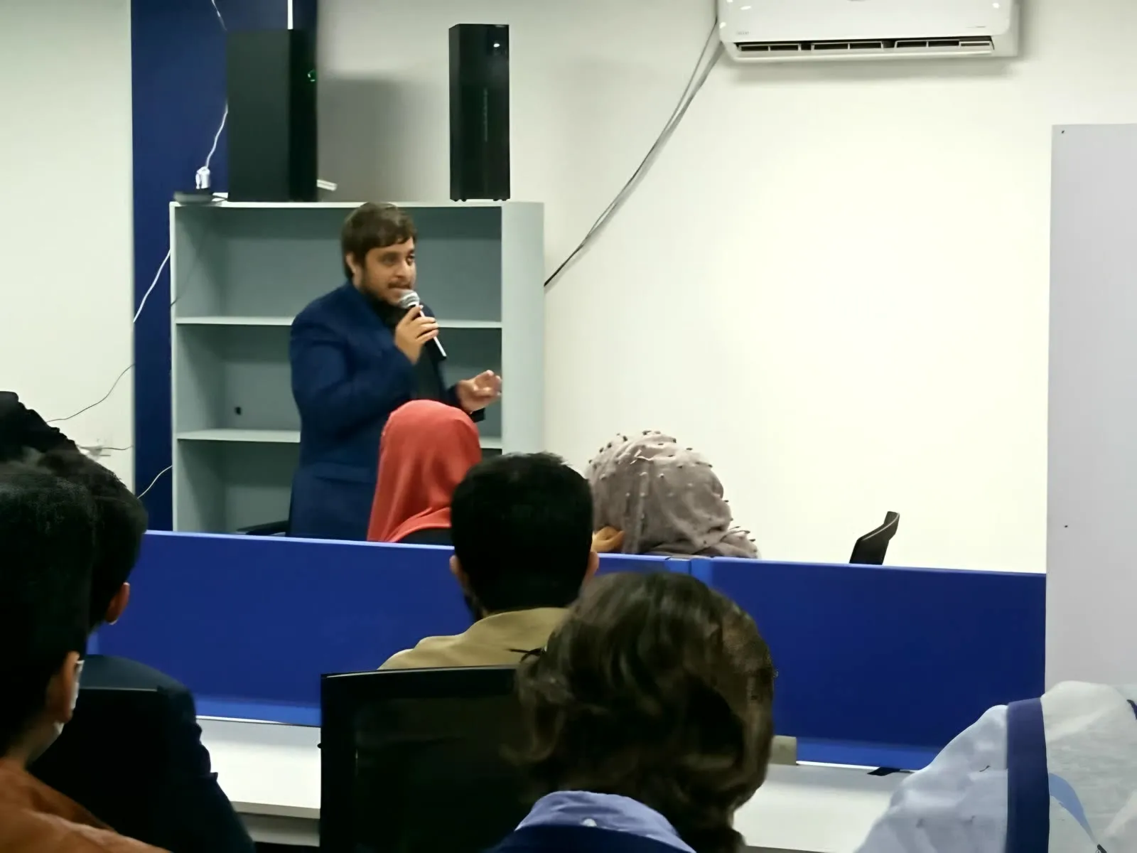 Taimoor Bamazai speaking with a microphone at the Extreme Commerce Lahore General Meetup, February 2021