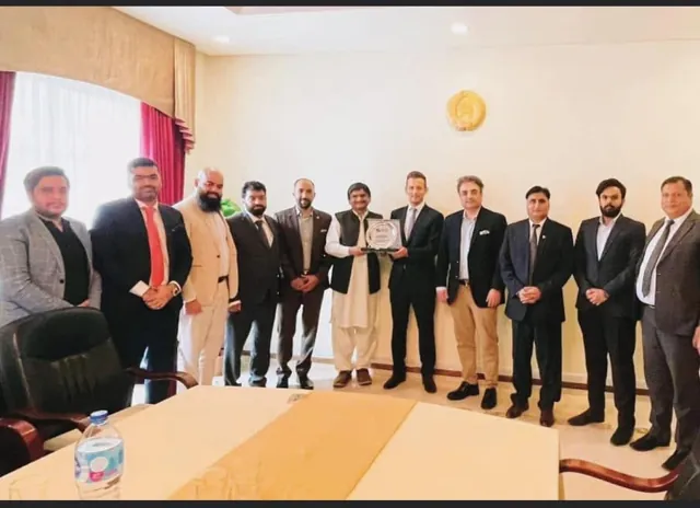 A delegation in business dress standing in a meeting room