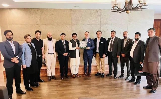 A delegation in business dress standing together in an embassy hall