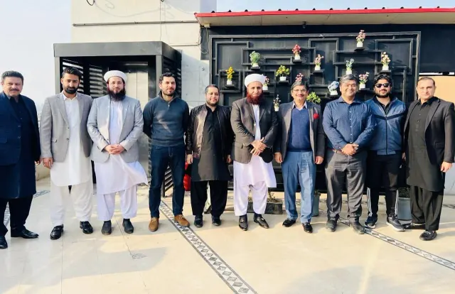 Taimoor Bamazai standing with a group of ten people on a rooftop