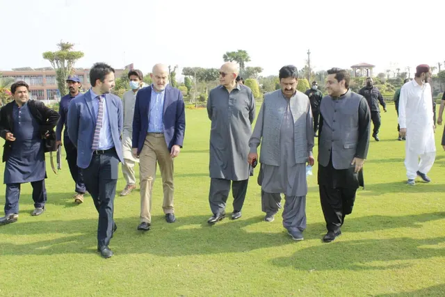 Taimoor Bamazai walking across a lawn with the Ambassador of Spain and hosts