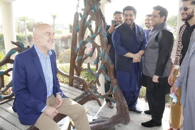 Taimoor Bamazai standing beside the seated Ambassador of Spain