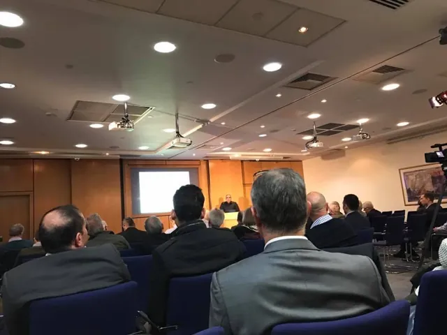 An audience watching a presentation in a meeting room