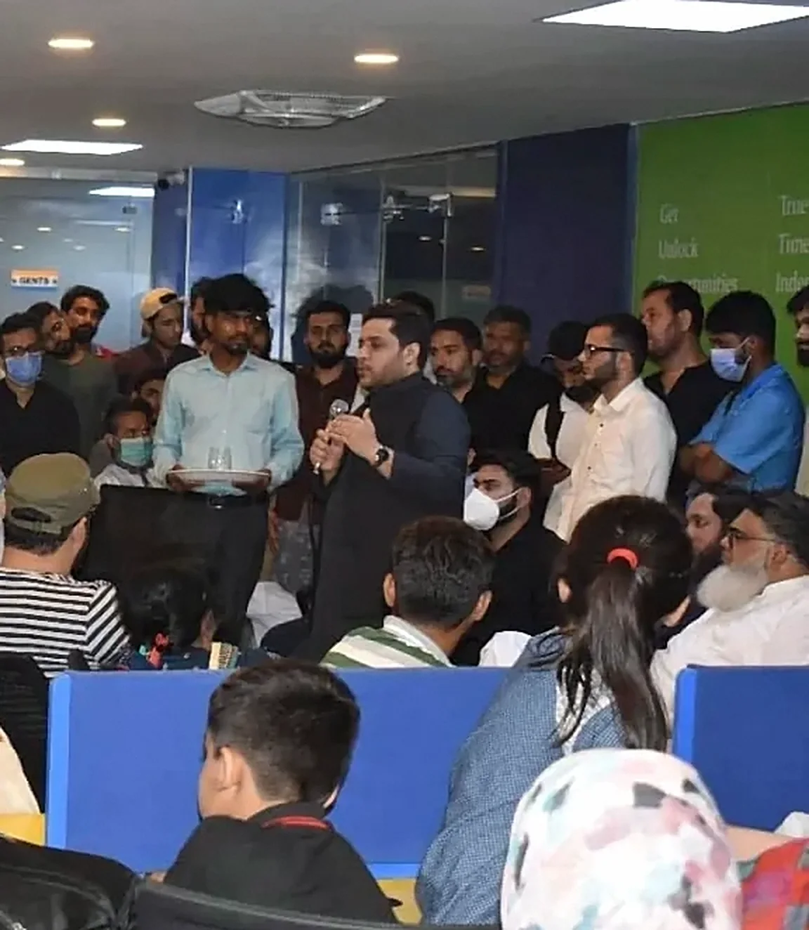 Taimoor Bamazai speaking with a microphone to a packed e-commerce session in Islamabad
